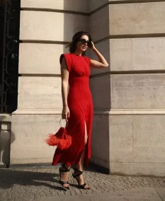 Invitada de boda llevando un Vestido Midi Rojo perfecto con bolso rojo a juego