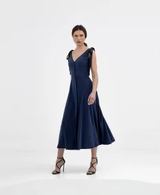 Midi design with feminine bows. Perfect for special occasions, this blue dress combines a classic A-line cut