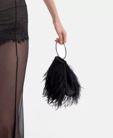 Lateral del diseño fluido del Vestido Ciane y bolso de fiesta en negro con pluma